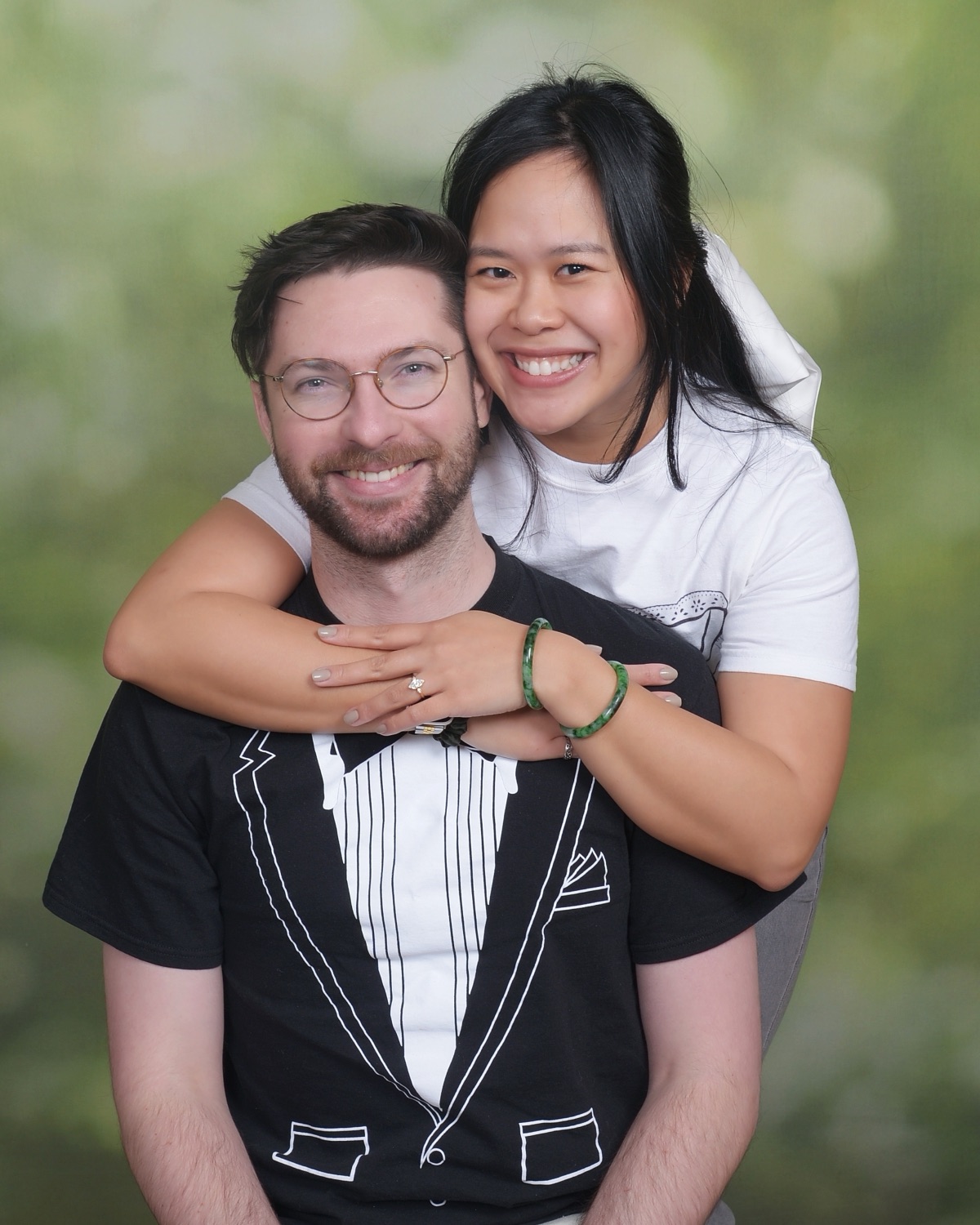 Nhi hugging Derek from behind, both laughing